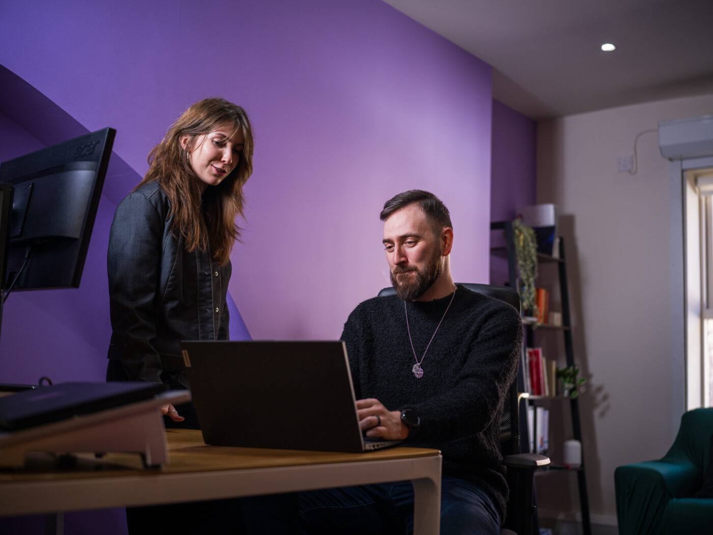 First Internet staff members looking at a computer inside a purple office