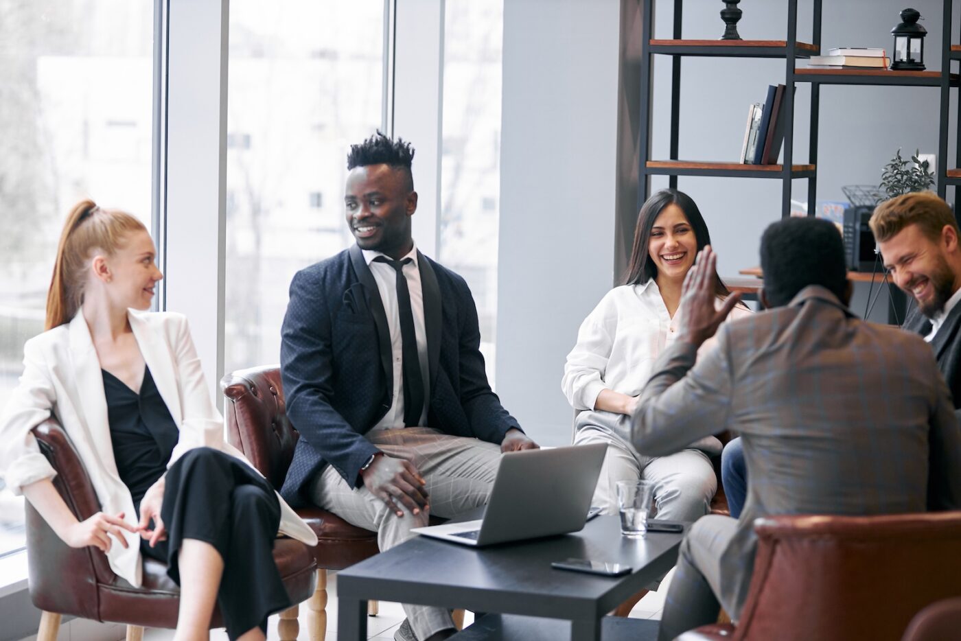 Legal team discuss business in modern office, wearing formal wear